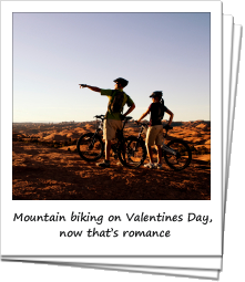 Couple mountain biking on slick rock in Moab, Utah
