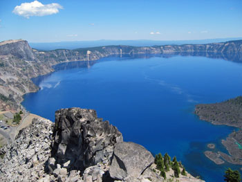 View of deep blue Crater Lake from Watchman Overlook and distant mountains