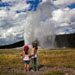 Two young girls watching Old Faithful erupt