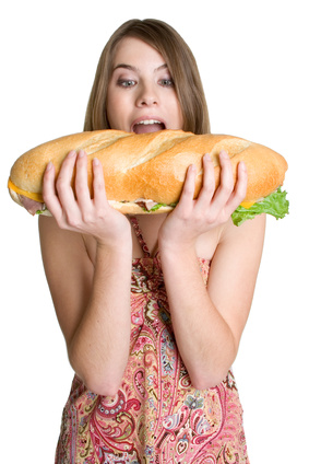Lady eating large turkey sandwich