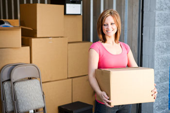 Young woman holding a box at a storage unit