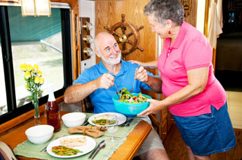 Seniors serving salad in their RV