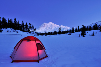 Lit tent perched on snow