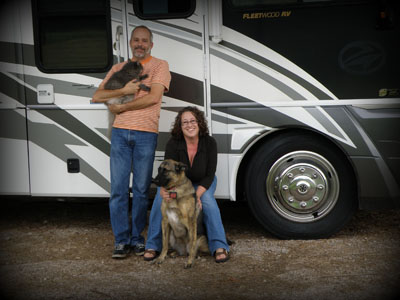 Keith and Tricia with their fluffy kids in front of their RV.