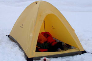 Light yellow single wall tent pitched in snow