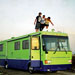 College kids standing on the roof of a green RV
