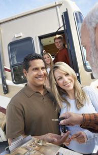 Salesperson handing over keys to the new owners of a class A motorhome