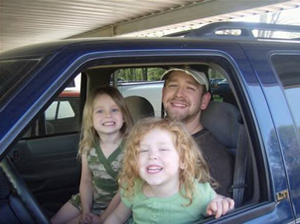 Two girls with father in car