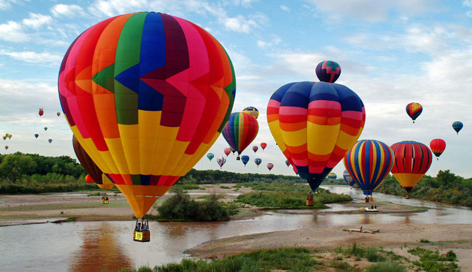 Lots of hot air balloons over a river