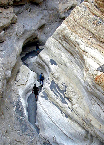 Hikers exploring the narrows of Mosiac Canyon, Death Valley National Park