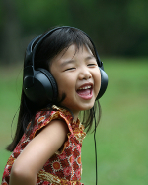 Young girl listening to music in the park
