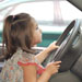 Little girl play driving in a car