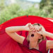 Lady waking up and yawning after sleeping in her red tent.