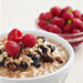 Bowl of oatmeal with raspberries, raisins and almonds