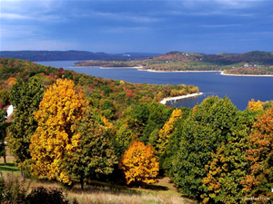 Yellow and green trees sit in the foreground with Table Rock Lake in the background