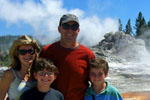 Bacon Family at Yellowstone National Park standing in front of a geyser