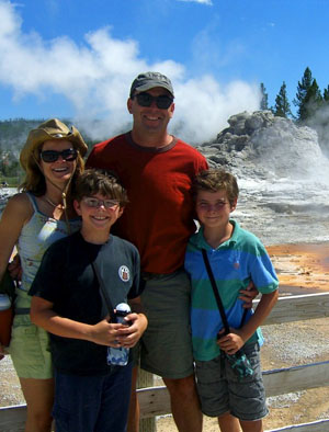 Bacon Family at Yellowstone National Park standing in front of a geyser