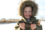 Child fishing in winter proudly displaying his catch