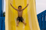 Young boy enjoying a ride on a water slide