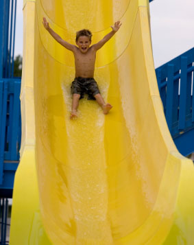 Young boy enjoying a ride on a water slide
