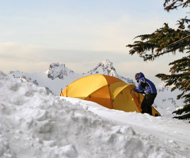 Man entering a tent in the snow
