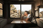 Man sitting at a table in an RV, looking out the window