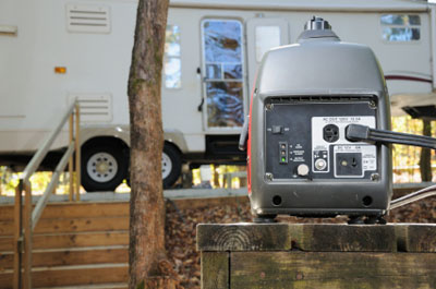 RV generator on a picnic table at campsite, in front of a Fifth Wheel