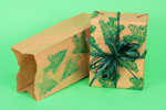 Brown paper bag being repurposed as Christmas gift wrap on green background