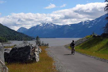 Cyclist on Indian to Girwood Bike Path with view of Turnagain Arm and mountains