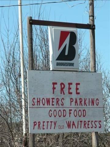 Road sign that reads "Free Showers Parking, Good Food, Pretty old waitress's"