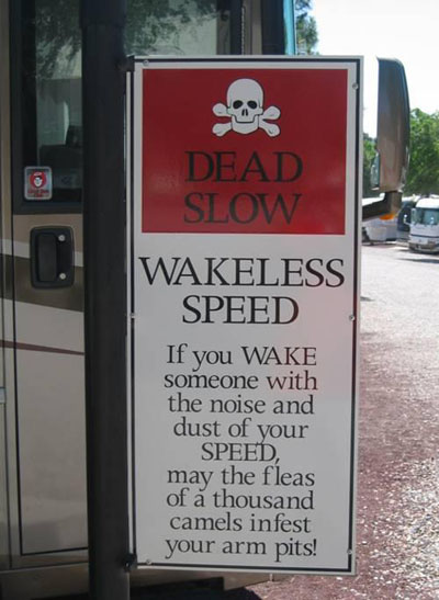 Campground sign that reads "Dead slow, wakeless speed. If you wake someone with the noise and dust of your speed, may the fleas of a thousand camels infest your arm pits"