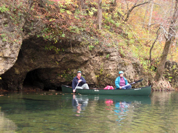 Couple canoeing by water cave on Current River