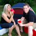 Couple drinking and sitting on coolers at their campsite