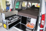 QuQuQ with stove, compartments and mattress, in a vehicle