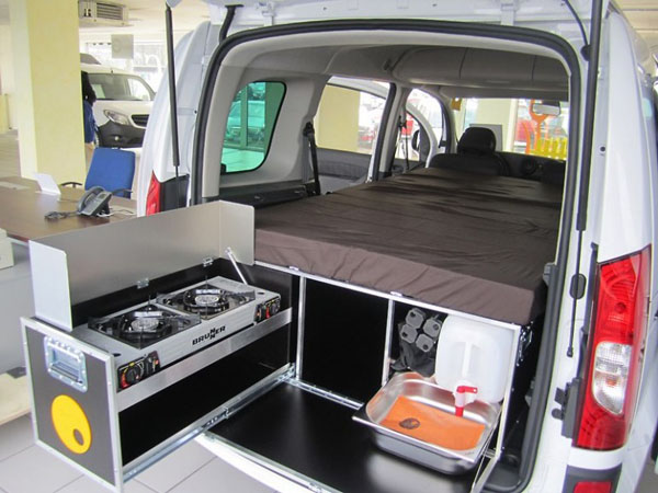 QuQuQ with stove, compartments and mattress, in a vehicle