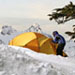Man entering a tent in the snow