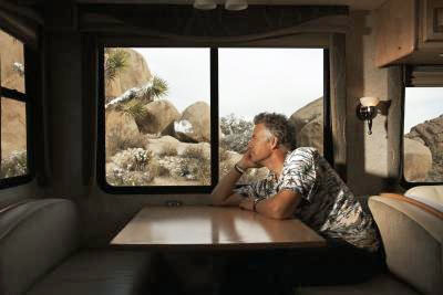 Man sitting at a table in an RV, looking out the window
