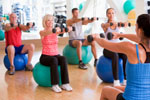 Instructor taking an exercise class at gym using fitness balls