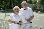An elderly couple playing tennis