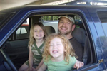 Two girls with father in car