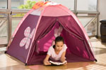 A young girl tent camping indoors